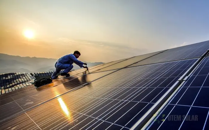 Installer working on a solar installation at sunset